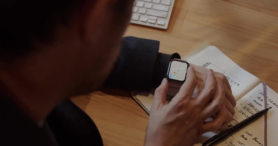 A man taps and scrolls on his smart watch