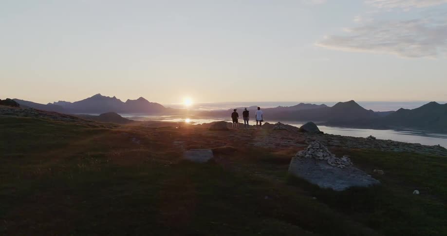 People stand on the rocks looking at the sunset