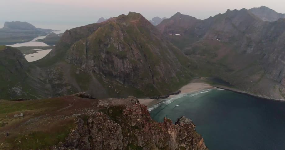 Hikers stand on a coastal mountain peak