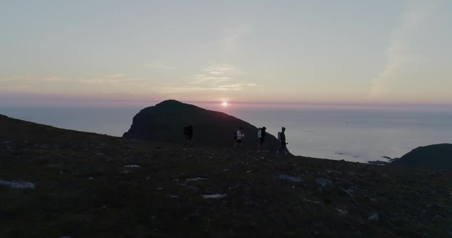 Sun sets over hills and a body of water