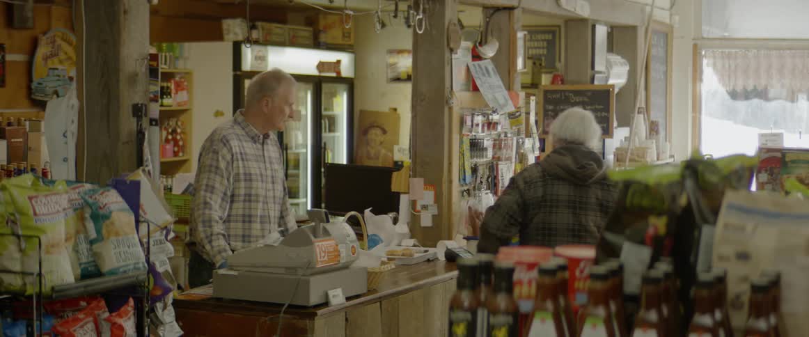 A clerk hands a package to a man at the register who then leaves