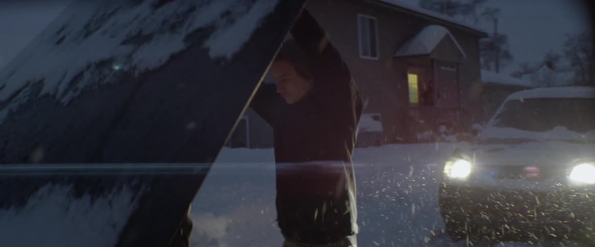 A man opens the hook of his car in the snow
