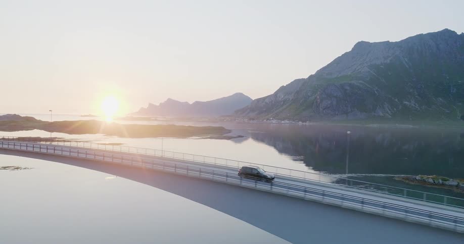 The car drives over the bridge at sunrise