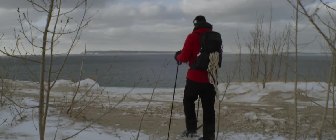 Man snowshoes near a lake