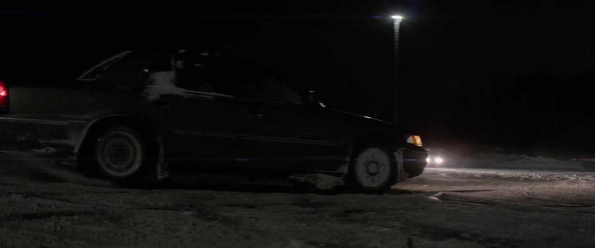 A car spins in a snowy parking lot