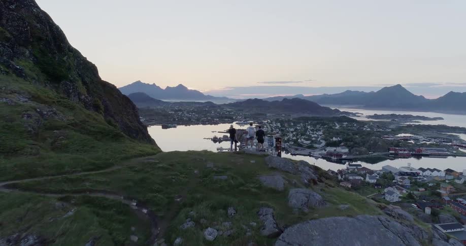 People stand on a cliff overlooking the town below