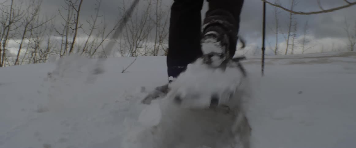 A person in snow boots wades through the deep snow