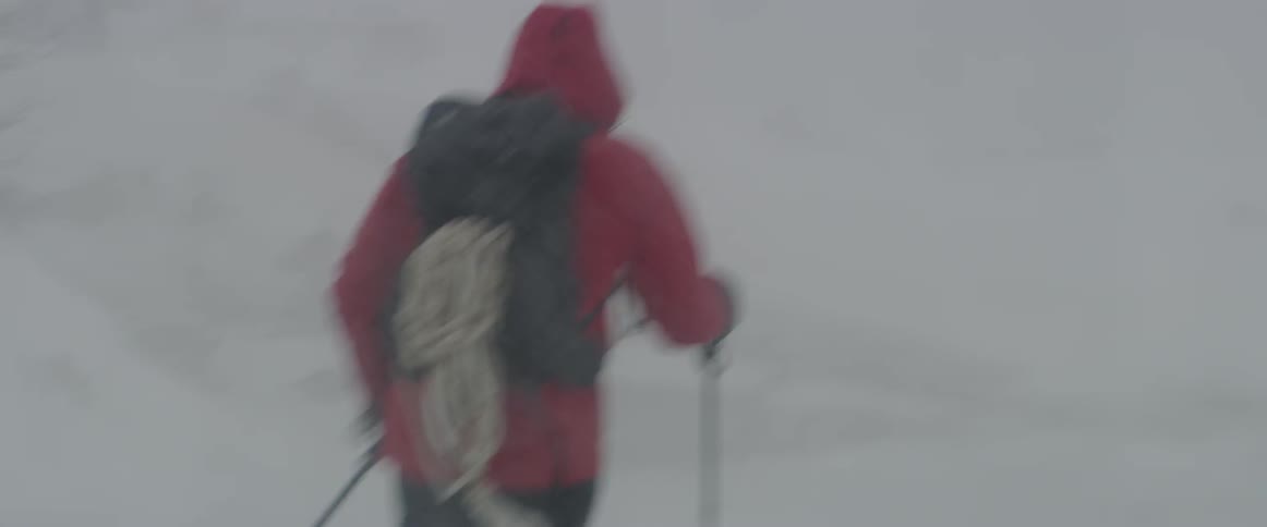 A man hikes in the heavy snow storm