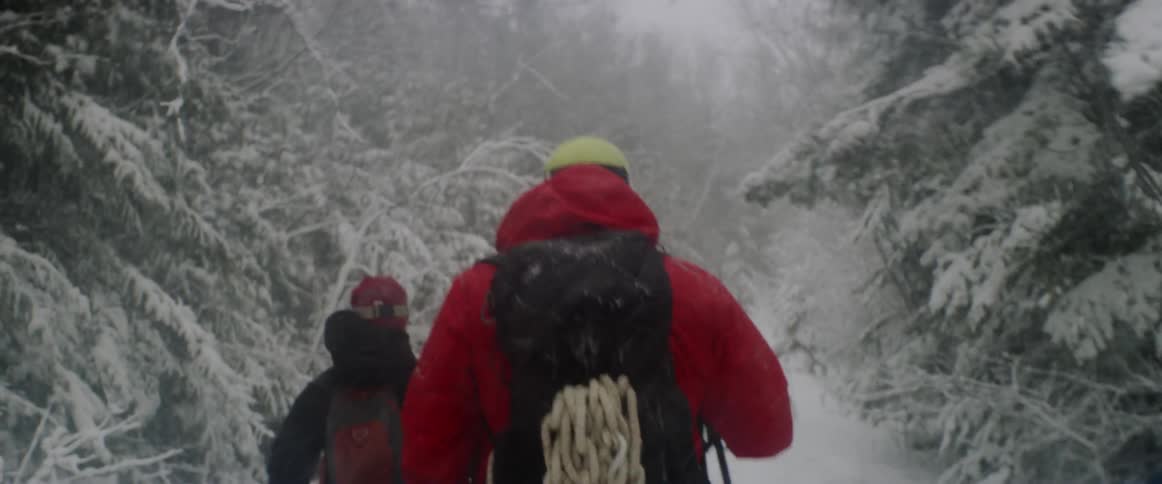 People hike uphill in the snow together
