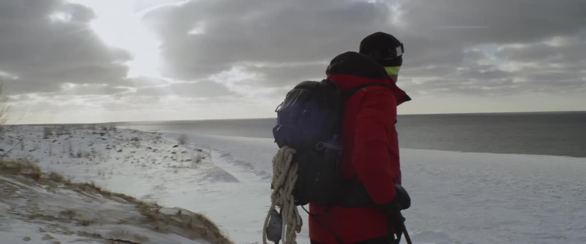 A man hikes in a snowy field
