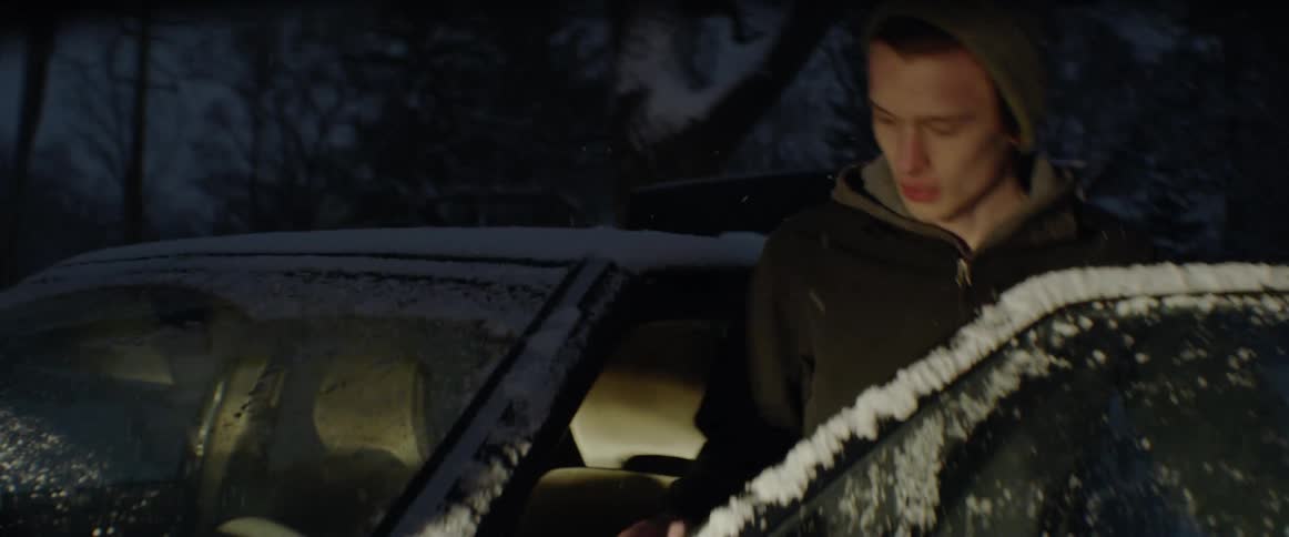 Man jumps a car battery in a snowstorm