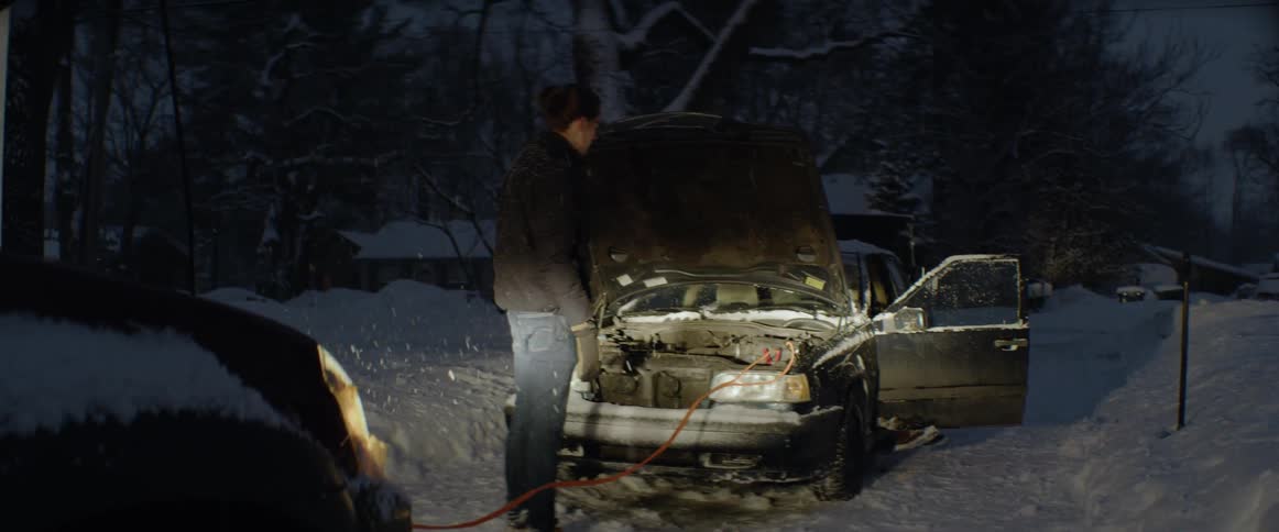 Man and woman try to boost the battery of a car