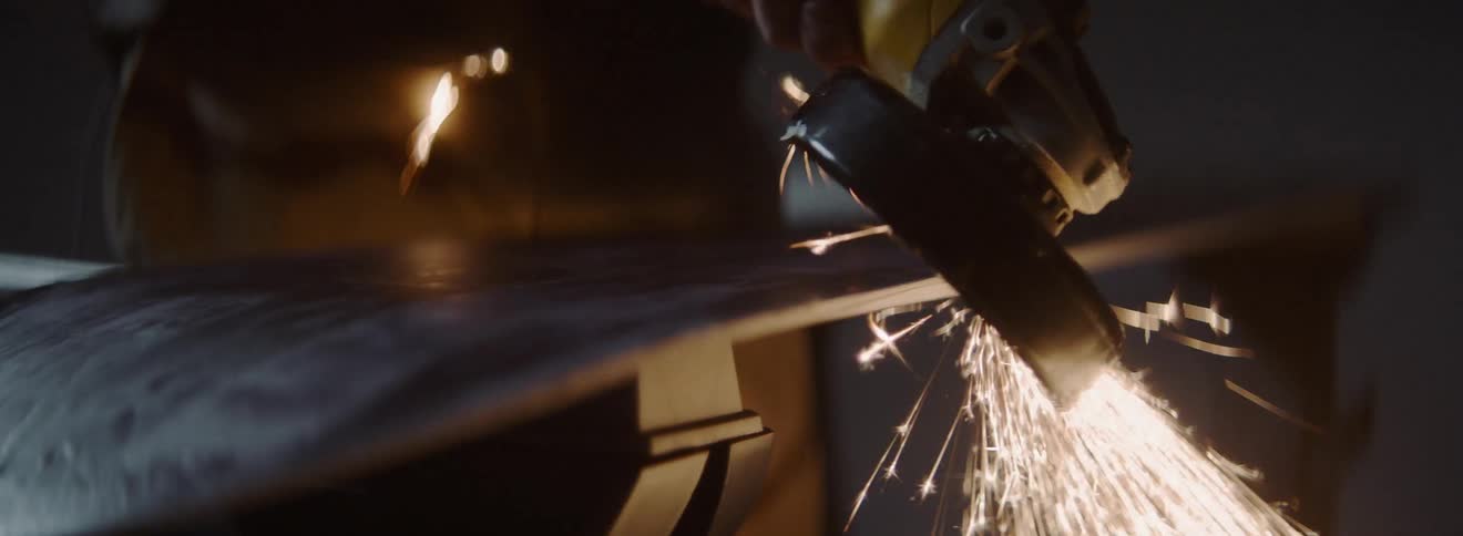 A man grinds a piece of steal