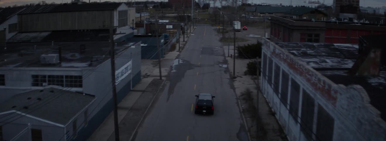 A vehicle drives down the empty street