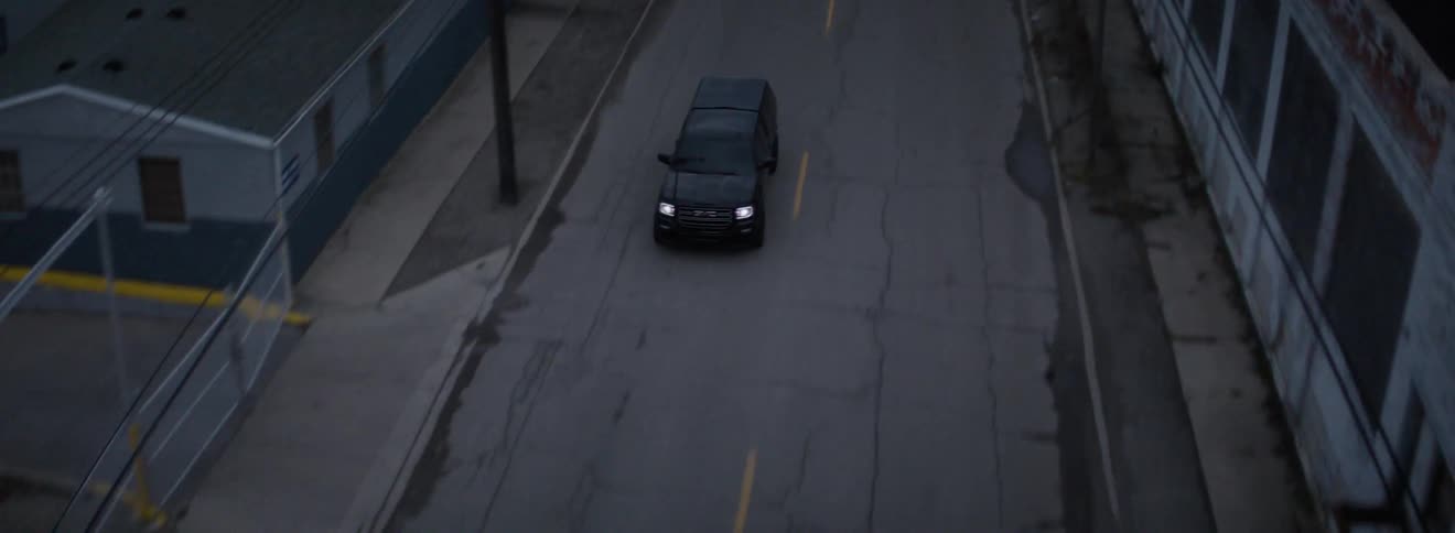 A truck drives down a desolate city road
