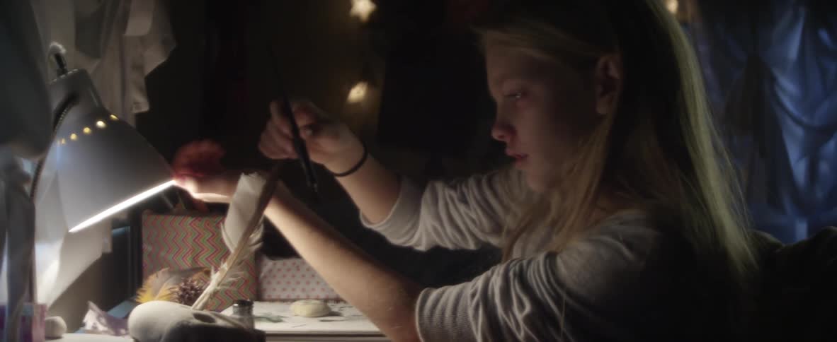 Blonde girl pulling up her sleeves and painting something on her wrists
