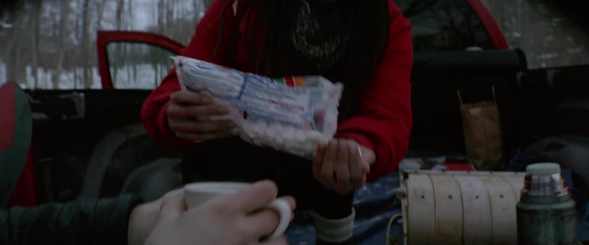 Friends drink hot chocolate in a truck bed