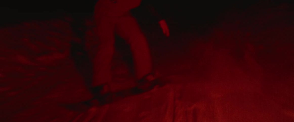 A man snowboards on a hill at night