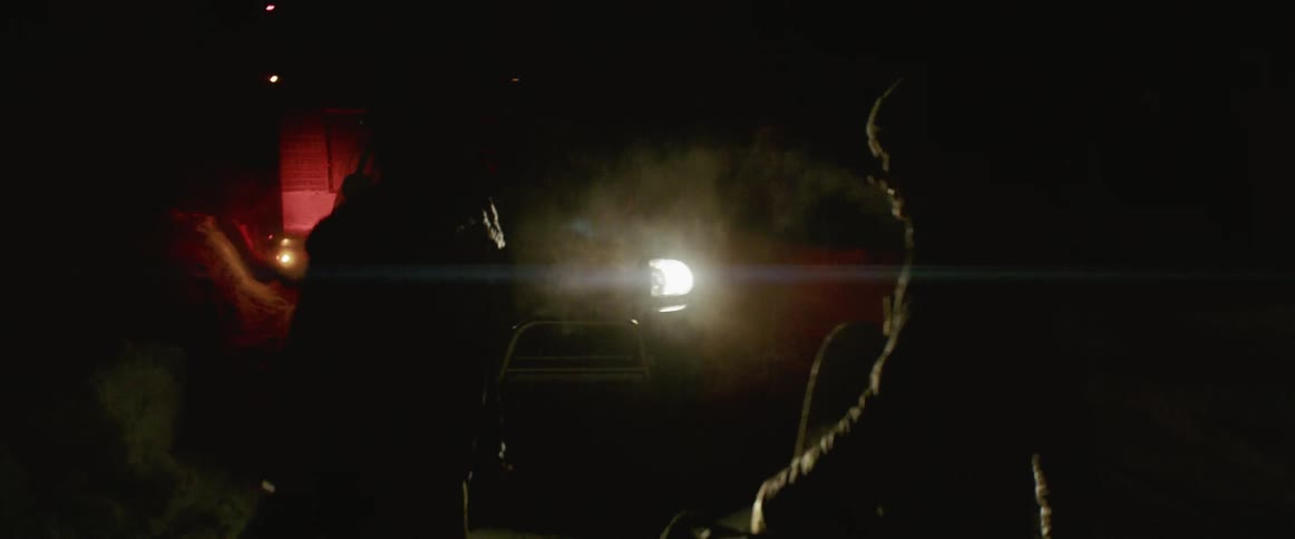 Two men high five in front of a truck at night