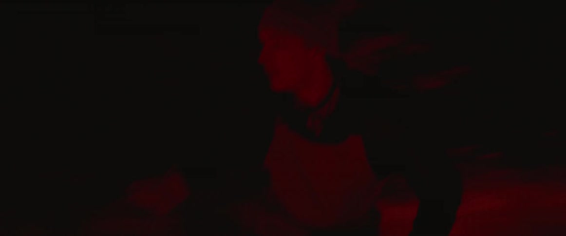 A man snowboards on a hill at night