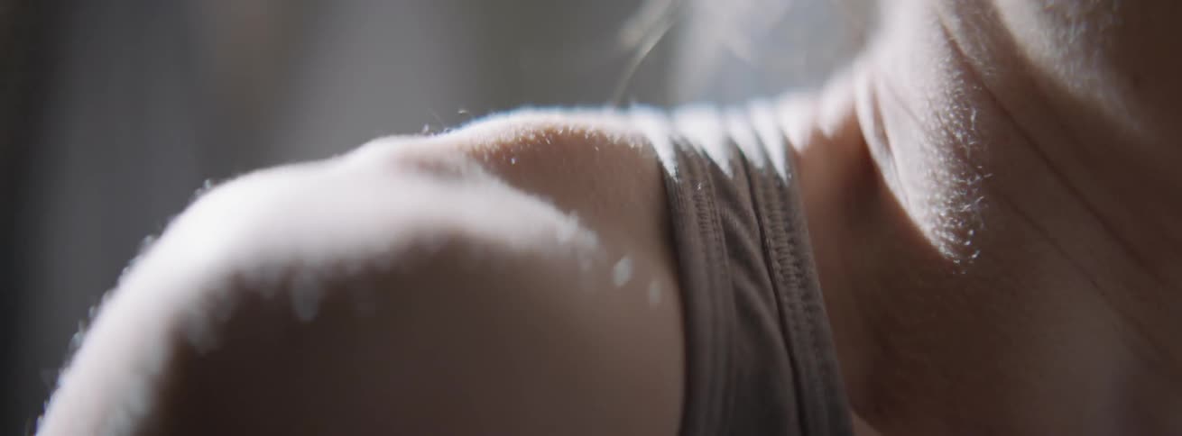 A trembling woman's shoulder has goosebumps