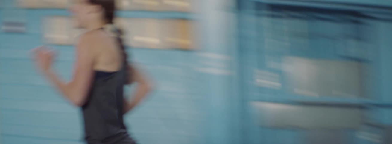 A woman is cheered on as she runs the track