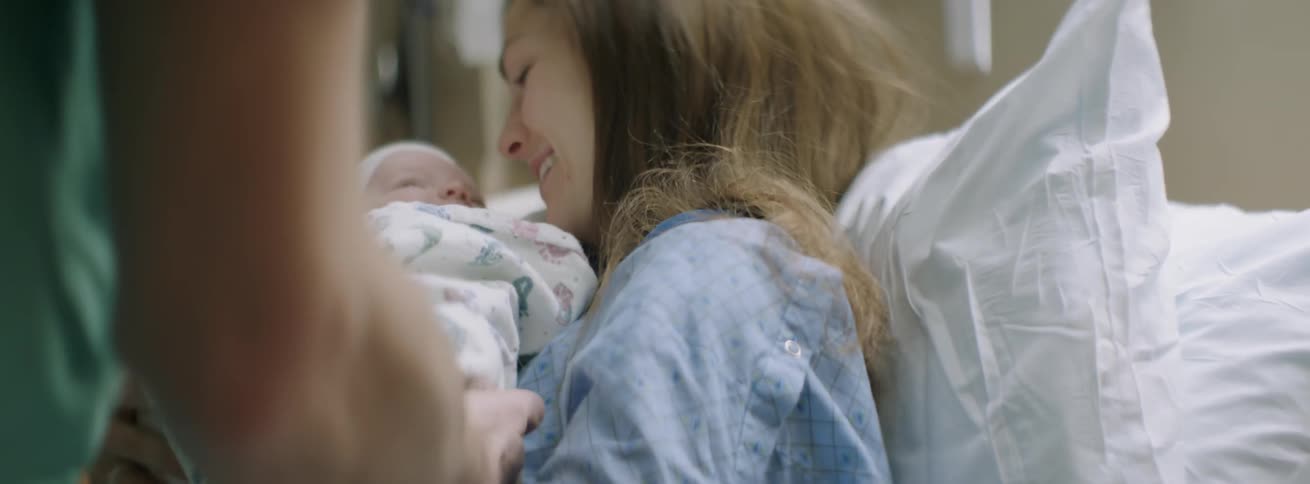 A woman is handed her newborn child