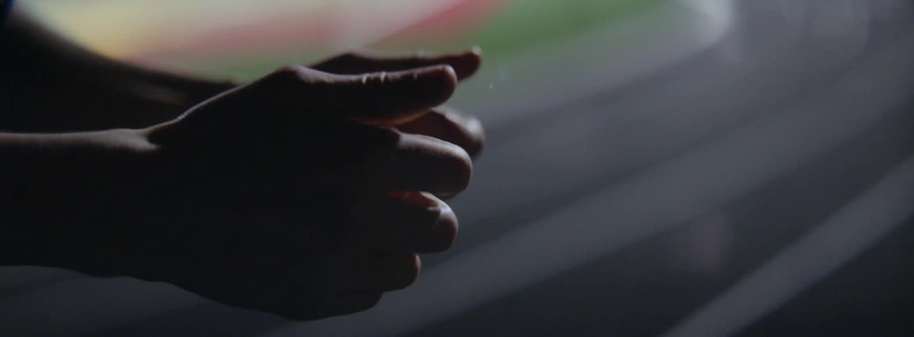 A person closes their hands into a fist then opens them palms up