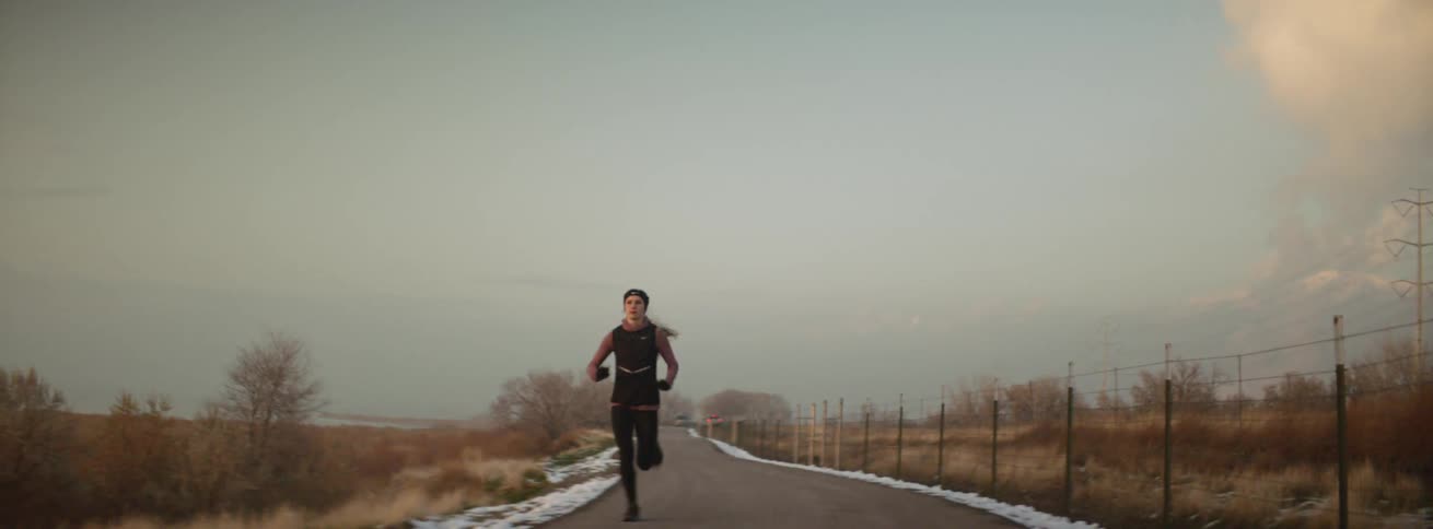 The woman runs fast down the trail