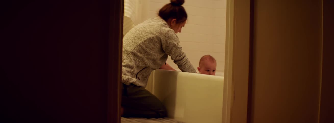 A woman is bathing a baby down the hall