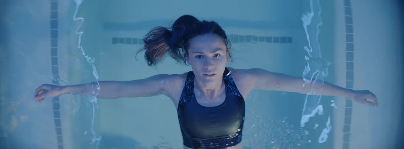 A woman floats in the pool water
