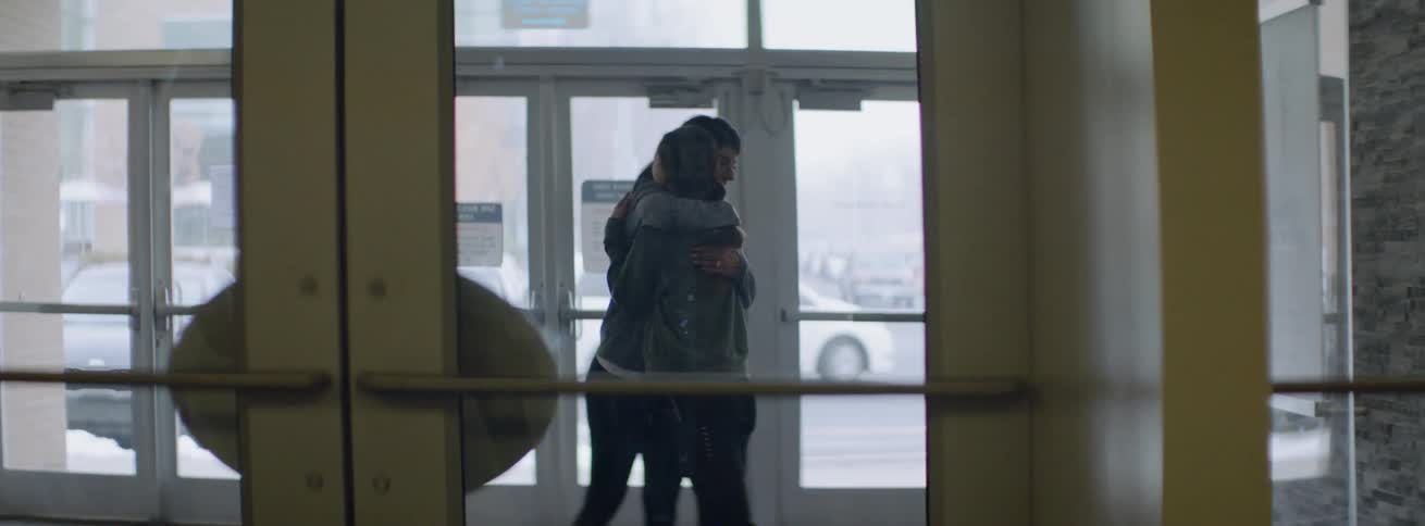 Two women hug in the lobby