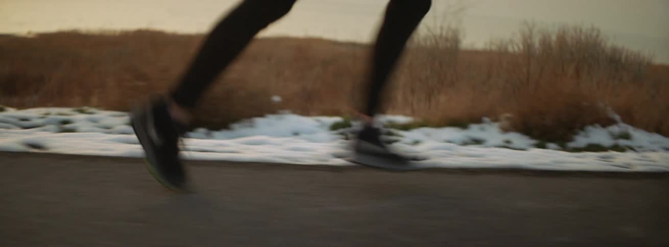 The woman is running outside by the snow