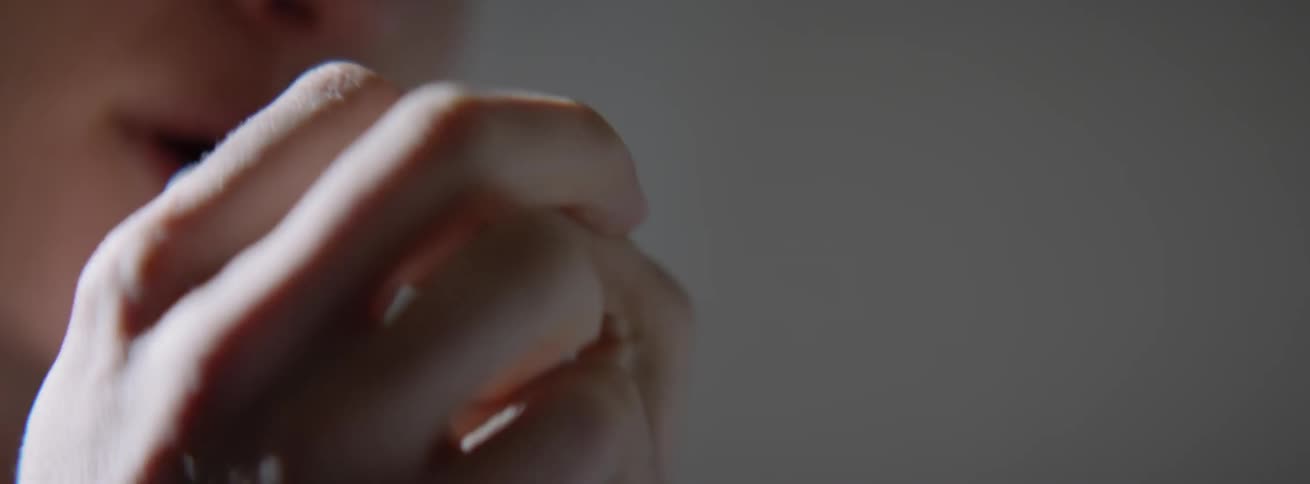 A woman fearfully shakes with her hands closed
