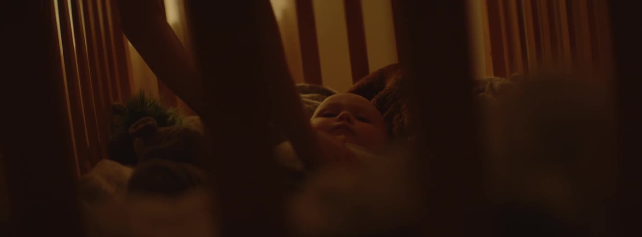 An infant is touched into their crib