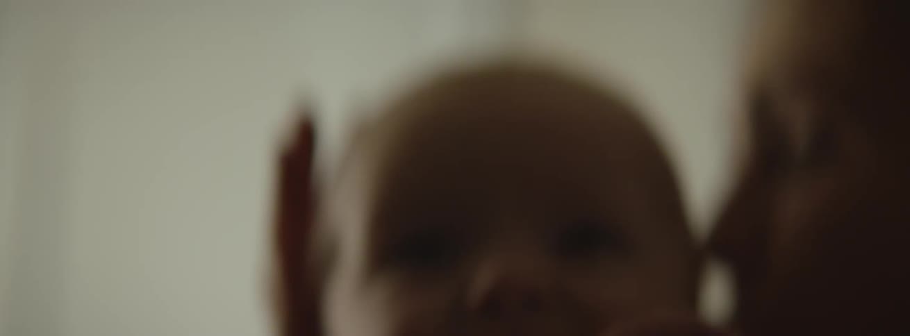 The baby is crying in a woman's arms