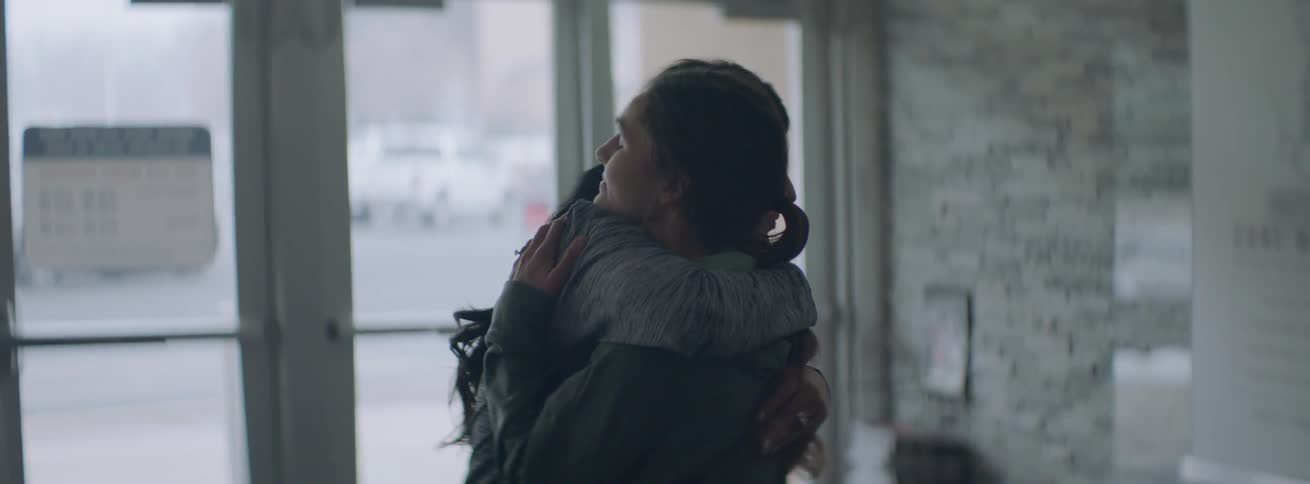 Two women hug and talk together