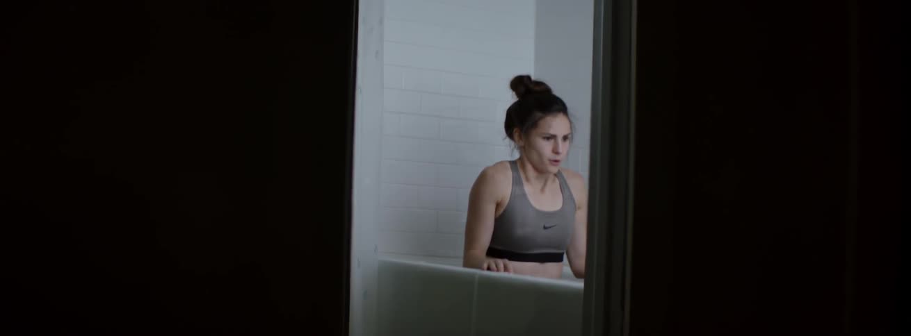 Woman sits in a bathtub of ice water