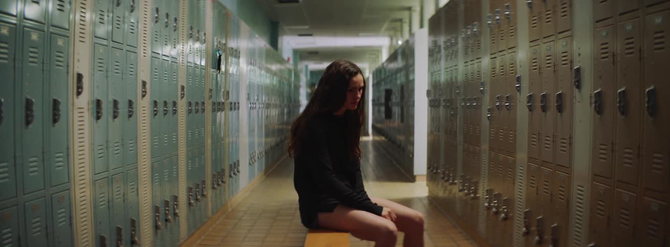 A woman sits on the bench in the locker room