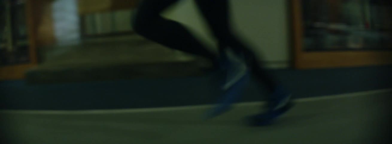 A woman jogs in blue shoes
