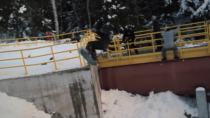 Snowboarder jumps off a railing and falls down below