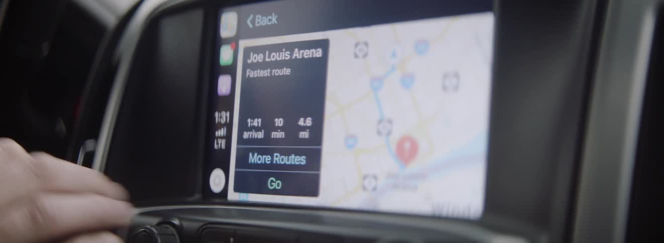 A driver is using a navigation system in a car during the day