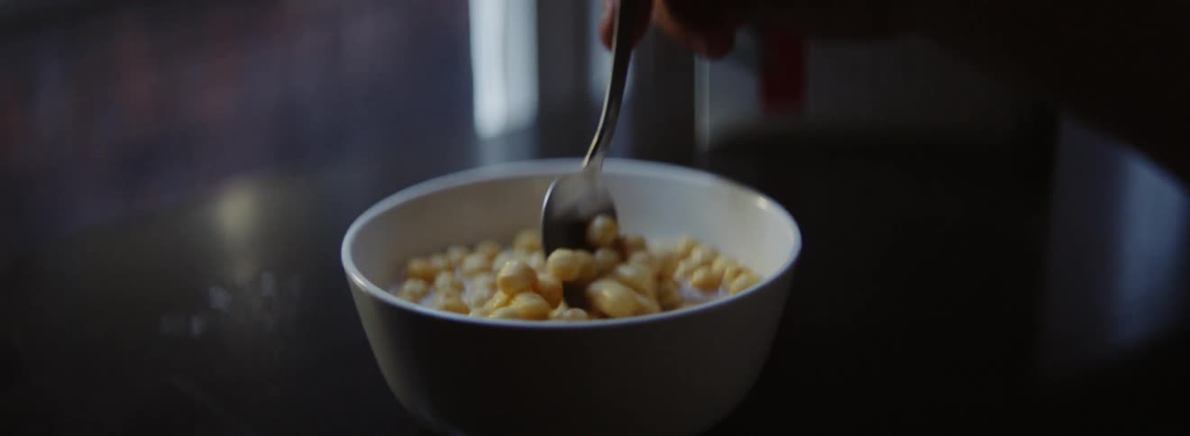A man is stirring his cereal in the morning
