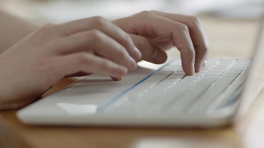 A woman uses a laptop on a table
