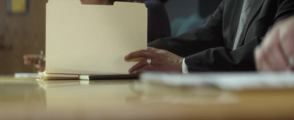 People sitting around a table looking through files and talking during a meeting