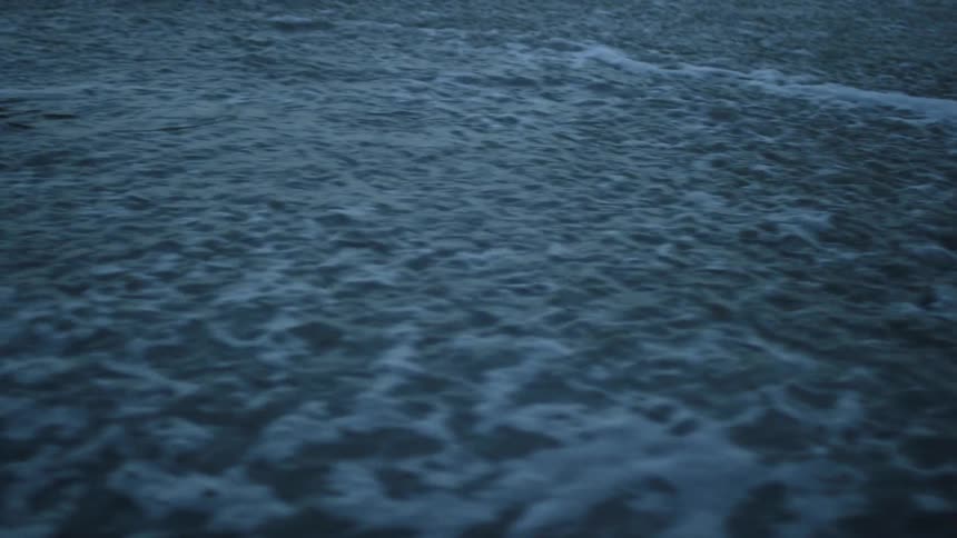 The waves slowly moves around near the shore
