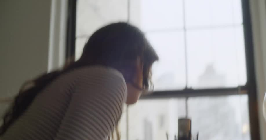 A woman takes off her headphones grabs her bag and leaves
