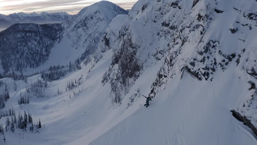 Sun shines through clouds over snowy mountains