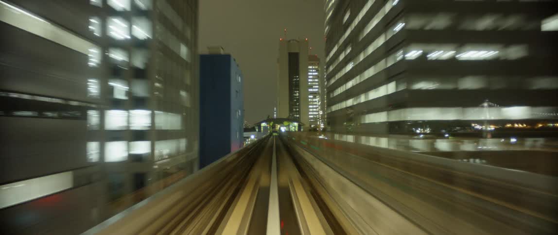 The train moves fast over the tracks at night