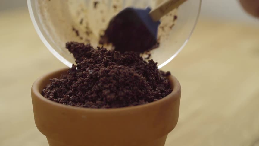 Dirt being put into a brown pot